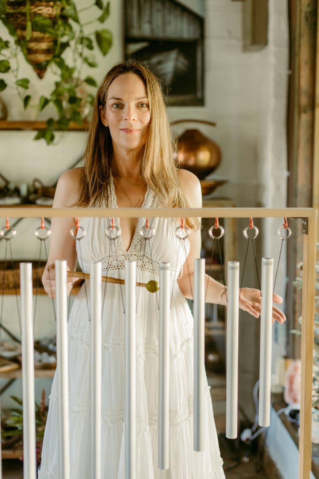 Miki standing beside a rack of tuned chimes, smiling
